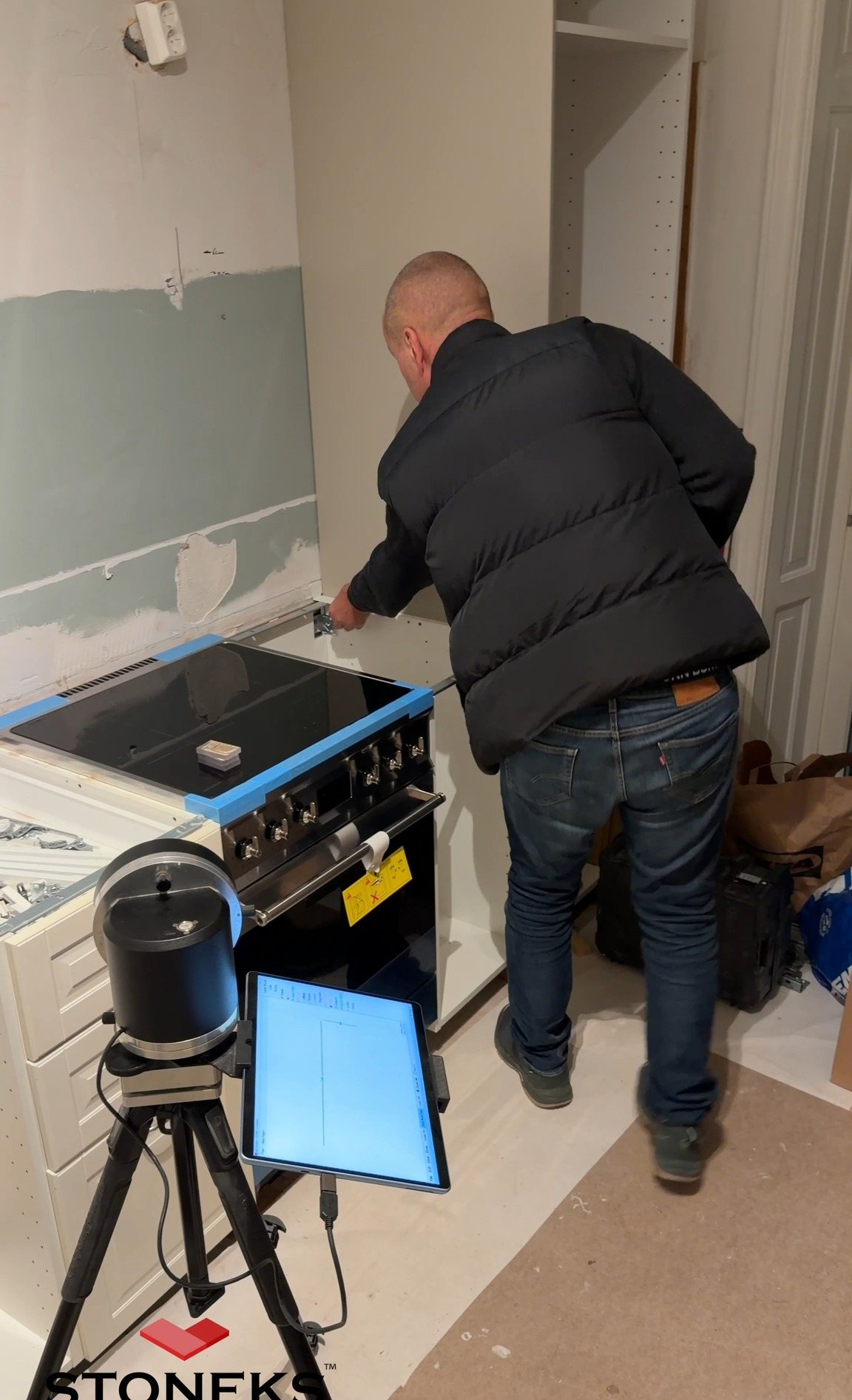 Stoneksin mittaaja mittaa keittiötason laserilla asiakkaan kotona