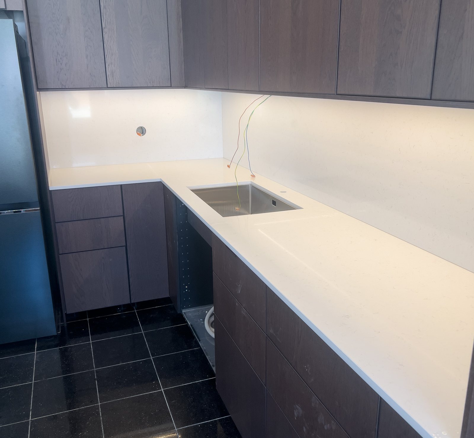 Technistone Noble Supreme White -kvartsitaso tummassa keittiössä – Stoneks Finlandin asennus, kuva 2