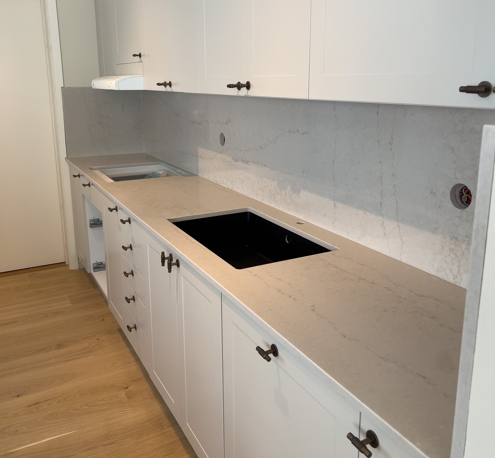Technistone Taj Mahal Gold -kvartsitaso vaaleassa shaker-keittiössä – Stoneks Finlandin asennus